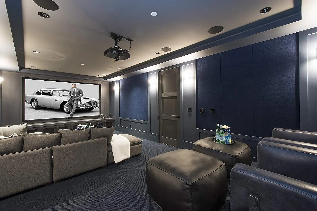 Home theatre with acoustic wall panels, a ceiling projector, and in-ceiling speakers.