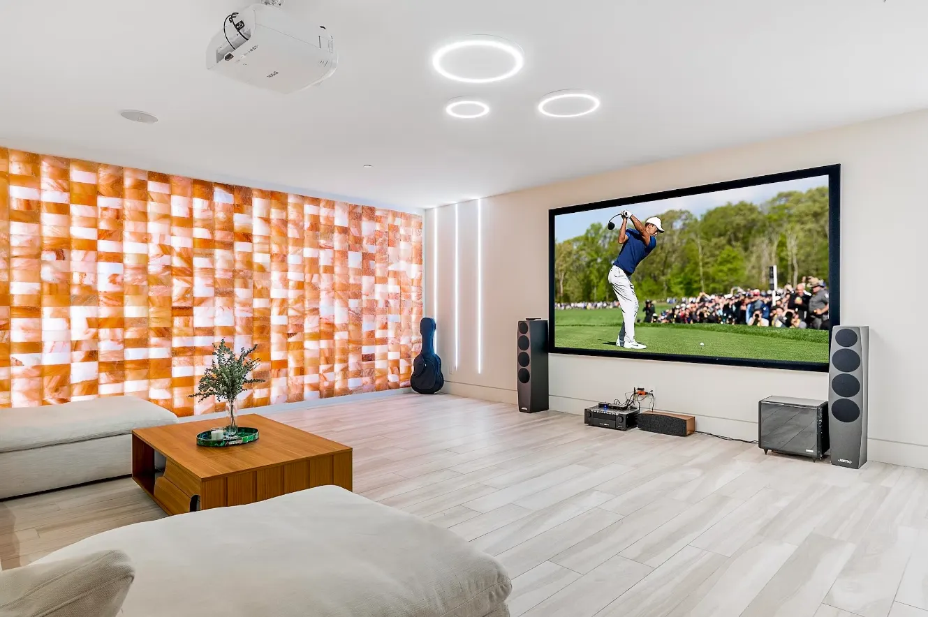 Media room with a ceiling projector, floorstanding speakers, and a subwoofer.