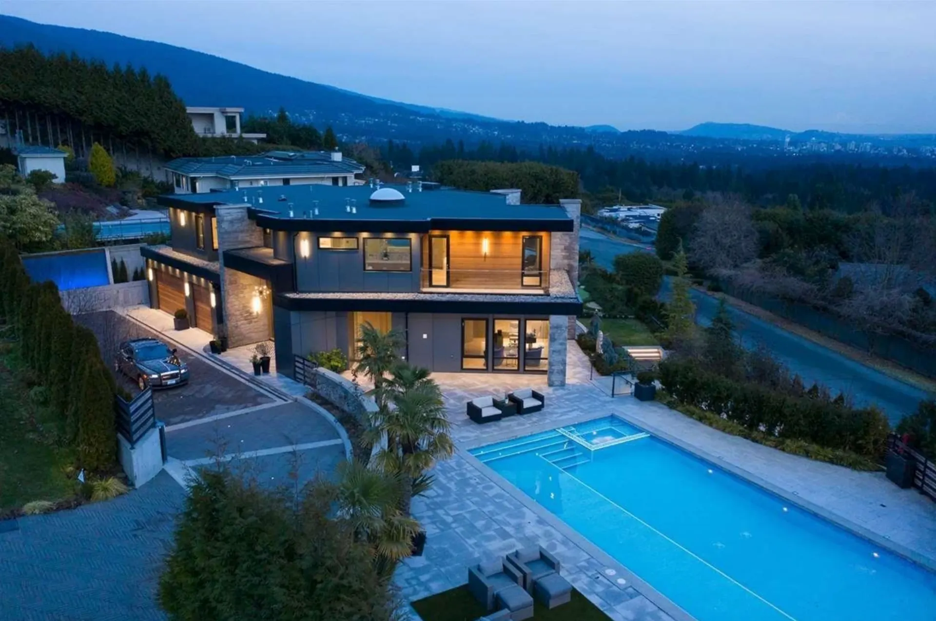 West Vancouver home at dusk with interior lights visible through the glazing.