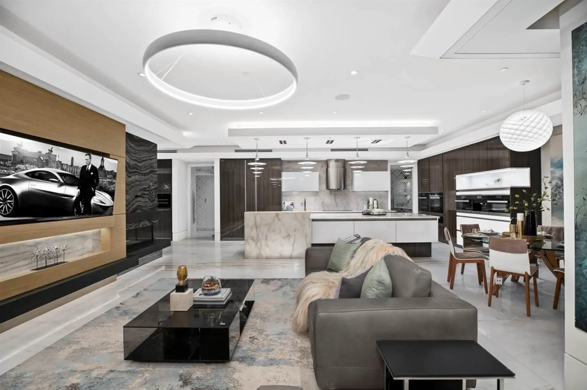 Living room with a flush-mounted television, a fireplace, and layered ceiling lights.
